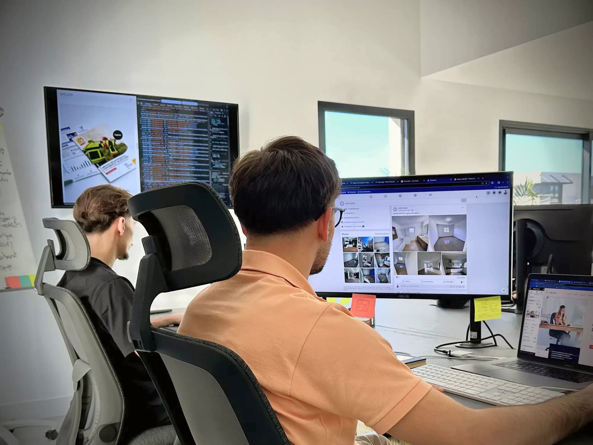 Deux membres de l’équipe DYCAST face à leurs écrans, du code et des maquettes de sites clients