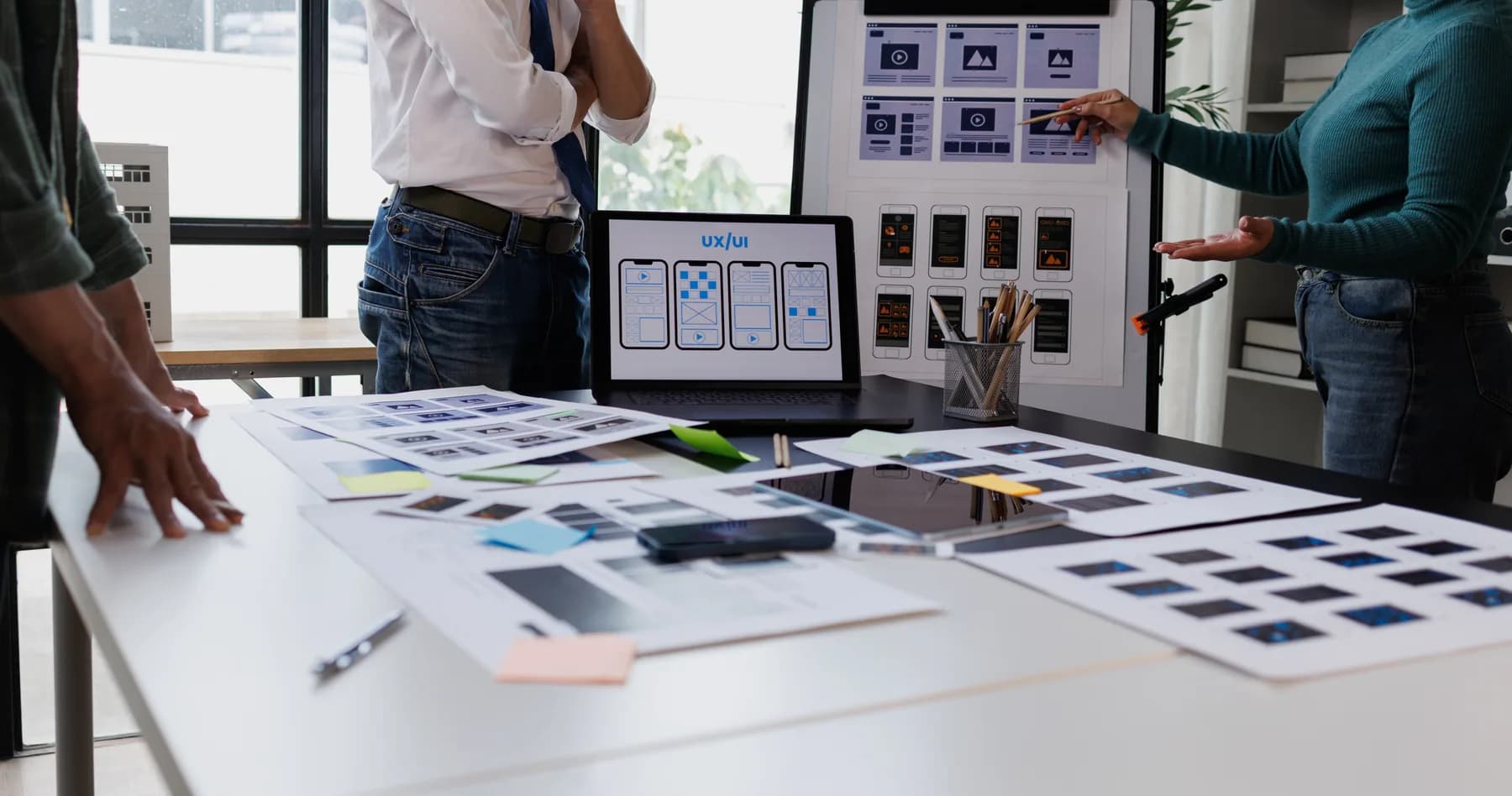 Une équipe travaille sur les maquettes d’un site autour d’une table