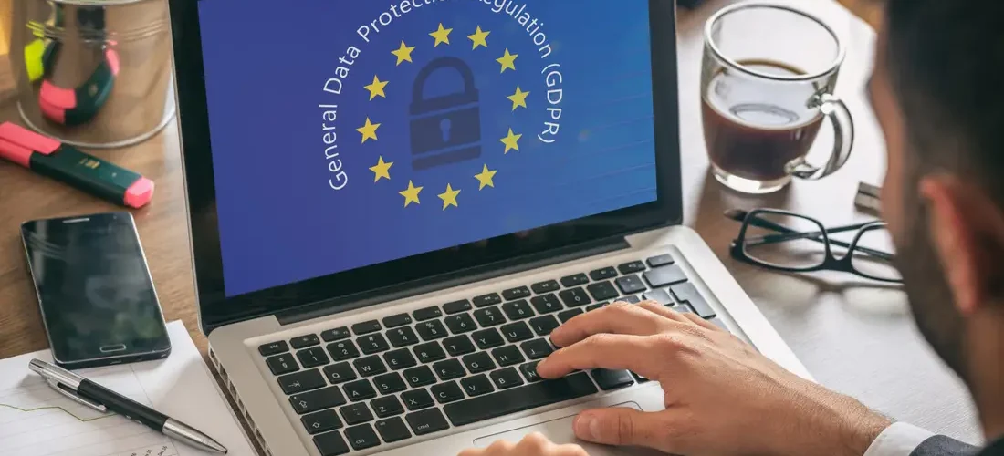 EU GDPR. Man working with a computer, General Data Protection Regulation and European Union flag on the screen